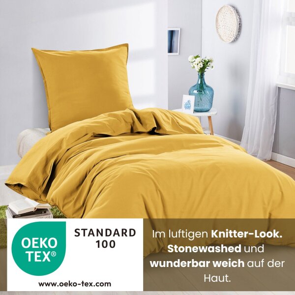 Ein Bett mit gelber Renforcé-Bettwäsche im Knitterlook, mit dem Hinweis, dass die Bezüge OEKO-TEX zertifiziert sind.