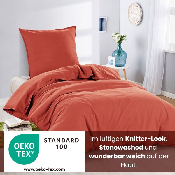 Ein Bett mit roter Renforcé-Bettwäsche im Knitterlook, mit dem Hinweis, dass die Bezüge OEKO-TEX zertifiziert sind.